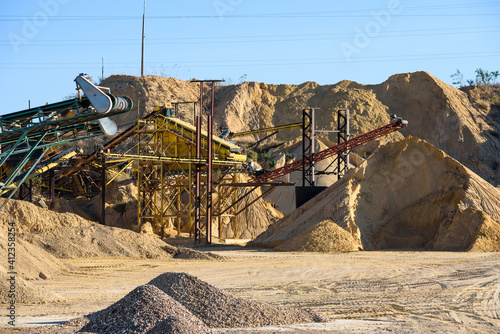 Velt conveyors and a piles of rubble in gravel quarry, crushed sand in different sizes. photo