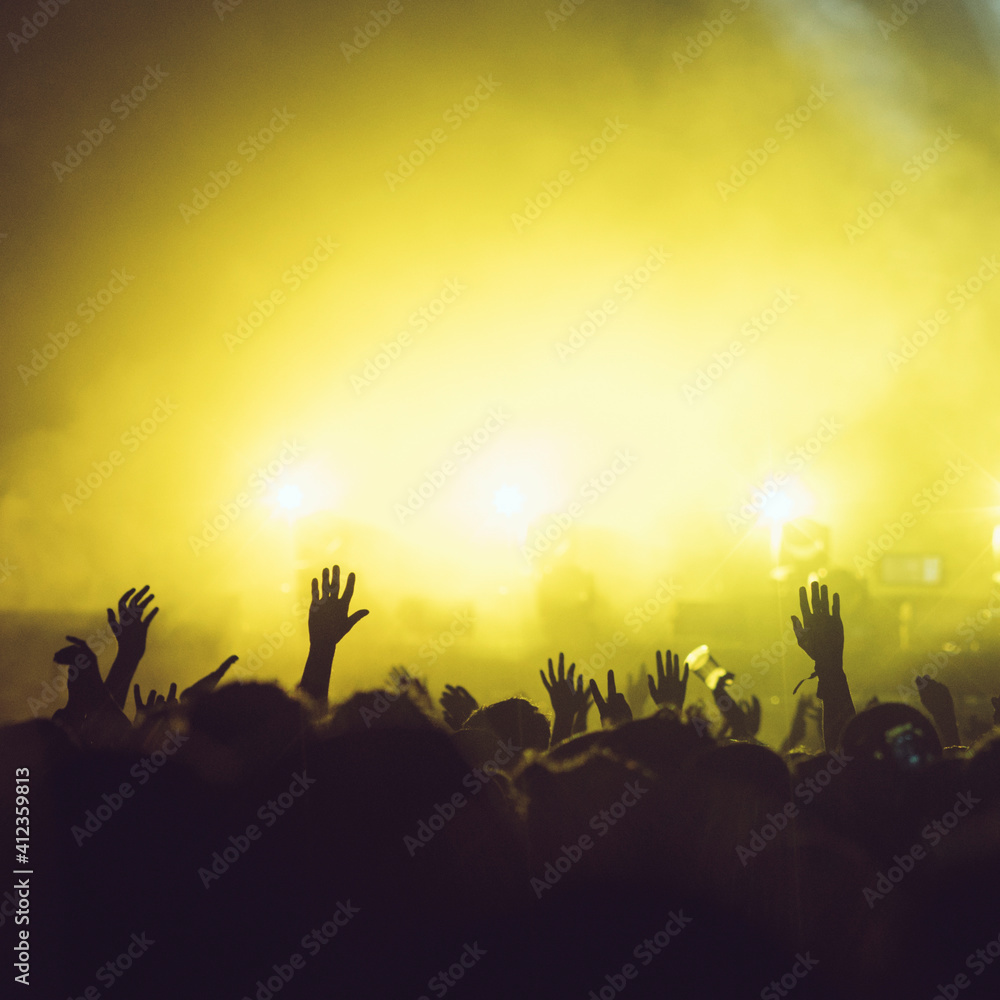 Sillhouettes of concert crowd in front of bright stage lights Sillhouettes of concert crowd in front of bright stage lights