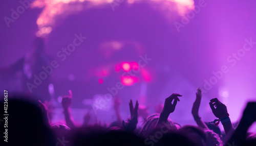 Sillhouettes of concert crowd in front of bright stage lights