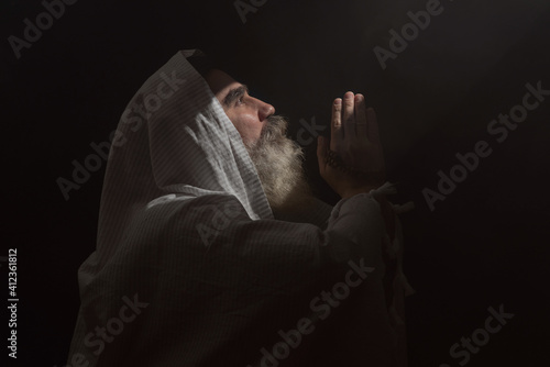 Foto A senior man standing in dark smoky background light ray from above