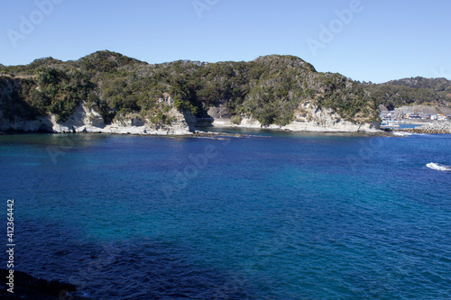 Katsuura Bay in Chiba Japan view, the ocean is a stunning deep blue color and the day is clear. It is a very idyllic scene. High cliffs and green hills. © Dane