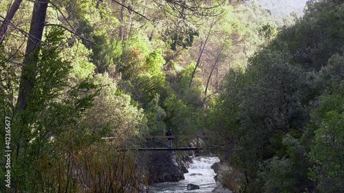 Sierra de Cazorla, Cerrada de Elías,Brunette girl crossing the river by the bridge