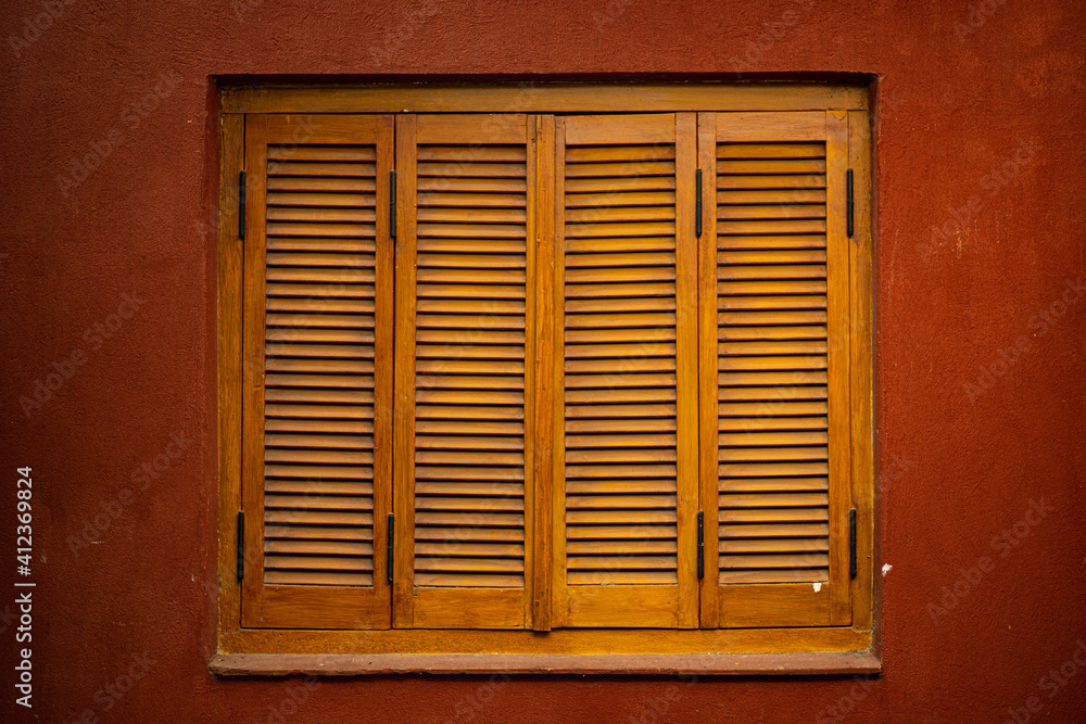 window with shutters on red wall window with shutters on red wall