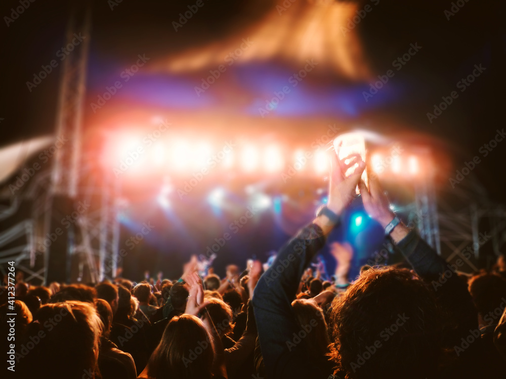 © Marcel/Stocksy - Cheering concert crowd at night © Marcel/Stocksy - Cheering concert crowd at night