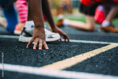 African-American Girl At The Start Line of a School Running Track photo