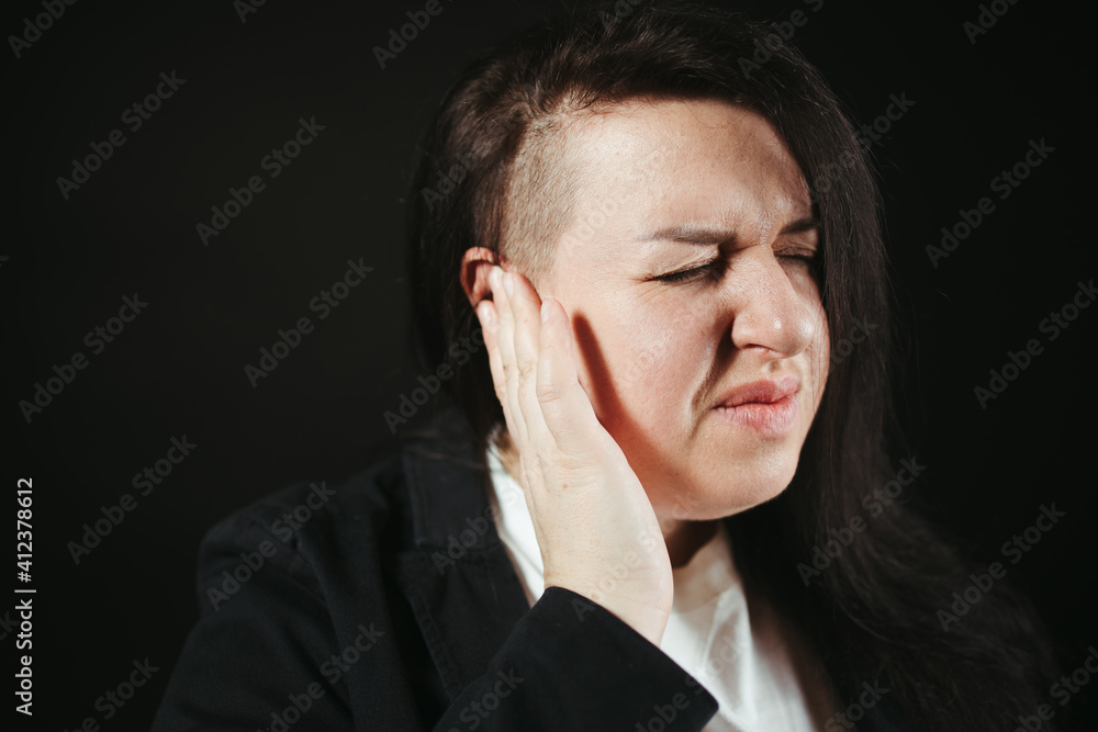 Girl with earache is holding aching ear Girl with earache is holding aching ear