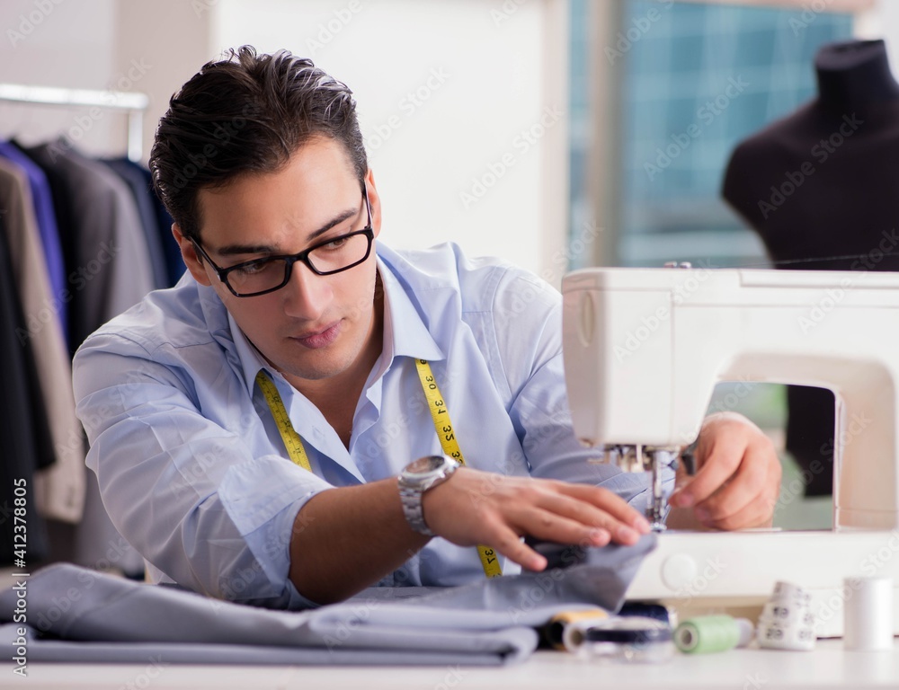 Young man tailor working on new clothing Young man tailor working on new clothing