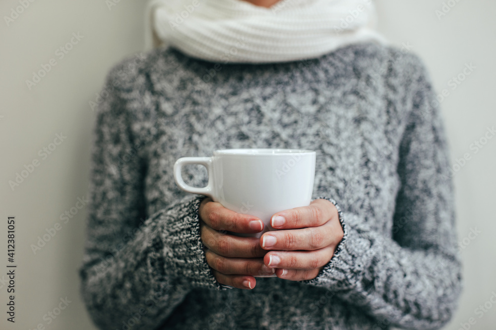 Woman with chunky knit sweater holding a hot cup of coffee. Woman with chunky knit sweater holding a hot cup of coffee.