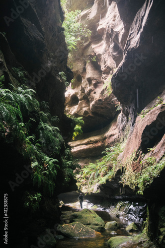 Man surrounded by rock walls in a canyon. photo