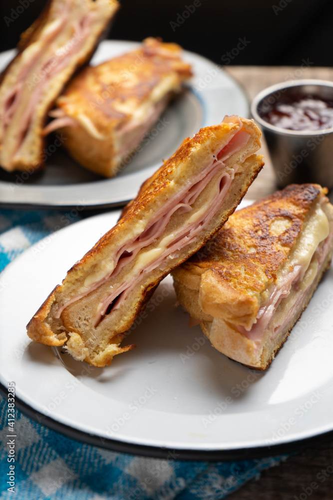 Ham and melted cheese sandwich called Monte Cristo on wooden background Ham and melted cheese sandwich called Monte Cristo on wooden background