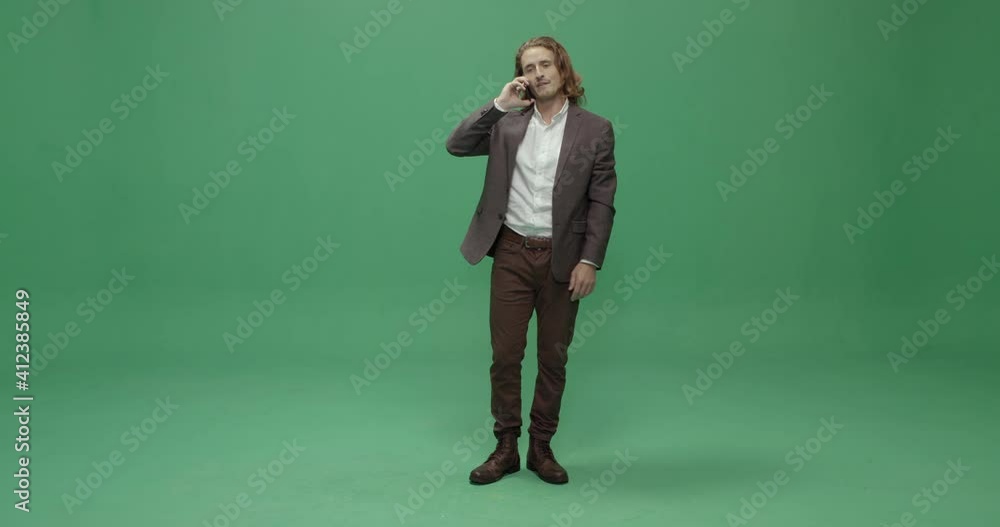 Studio, slow motion, green screen, a young man reluctantly answers his phone, London, UK Studio, slow motion, green screen, a young man reluctantly answers his phone, London, UK