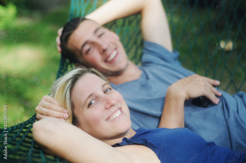 Young couple smiling and relaxing on a hammock Young couple smiling and relaxing on a hammock