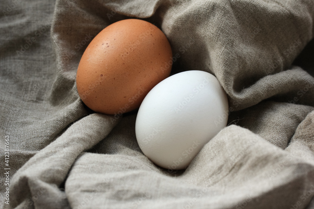 Two chicken eggs were wrapped in a linen napkin on the rustic table.Farm eggs. Two chicken eggs were wrapped in a linen napkin on the rustic table.Farm eggs.