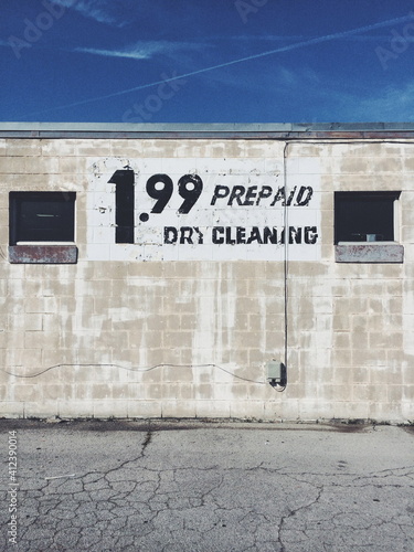Sign on a wall for prepaid dry cleaning for 1.99
