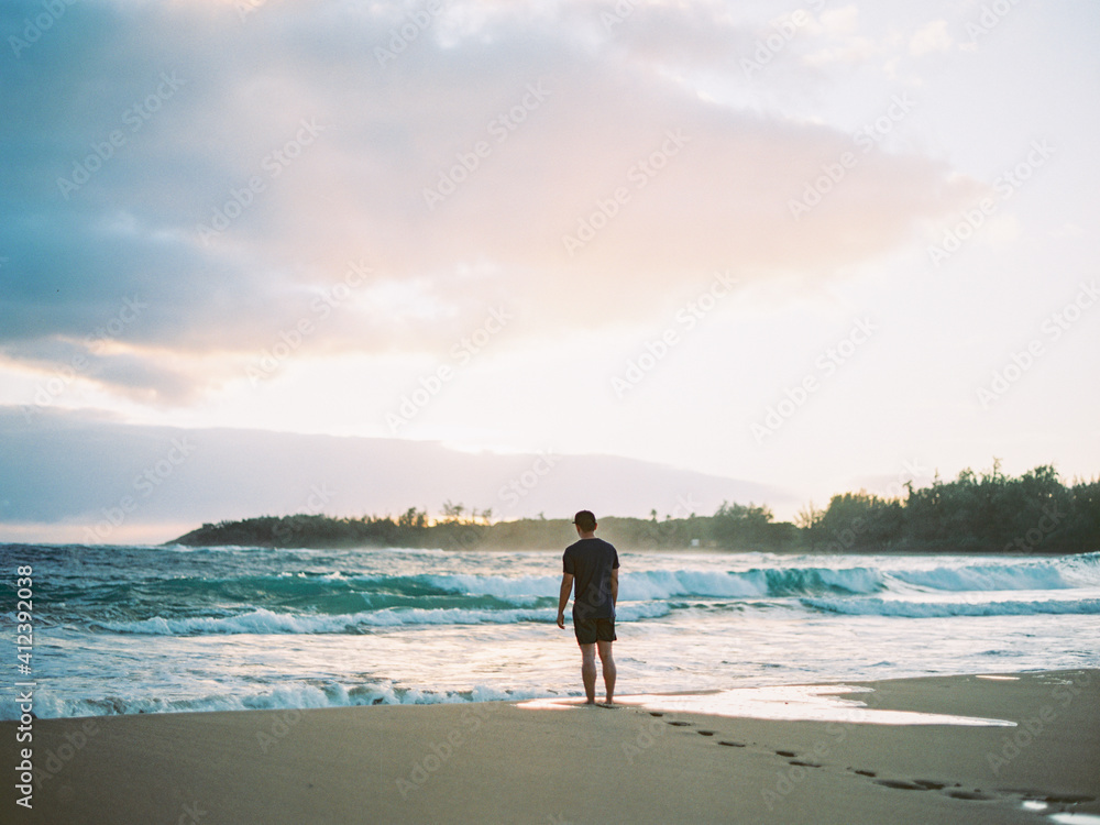 Man walking on beach at sunrise Man walking on beach at sunrise