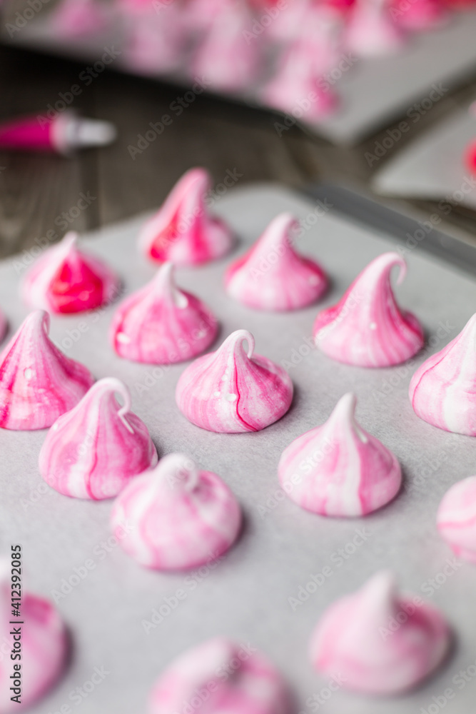 Pink meringue kisses on baking sheet Pink meringue kisses on baking sheet