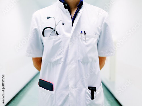Close up of a doctor in a white suit with a beeper and a stethoscope in a hospital photo