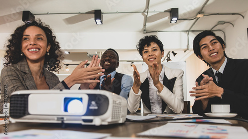 Businessmen and businesswomen Diversity of nationalities Clap your hands are attending the conference room with a smiling face and the projector to work at the office. Concept meeting show projector.