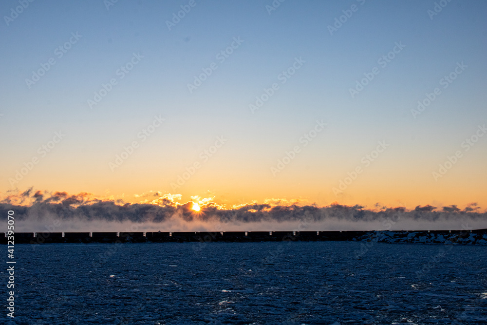 frigid sunrise over steaming lake