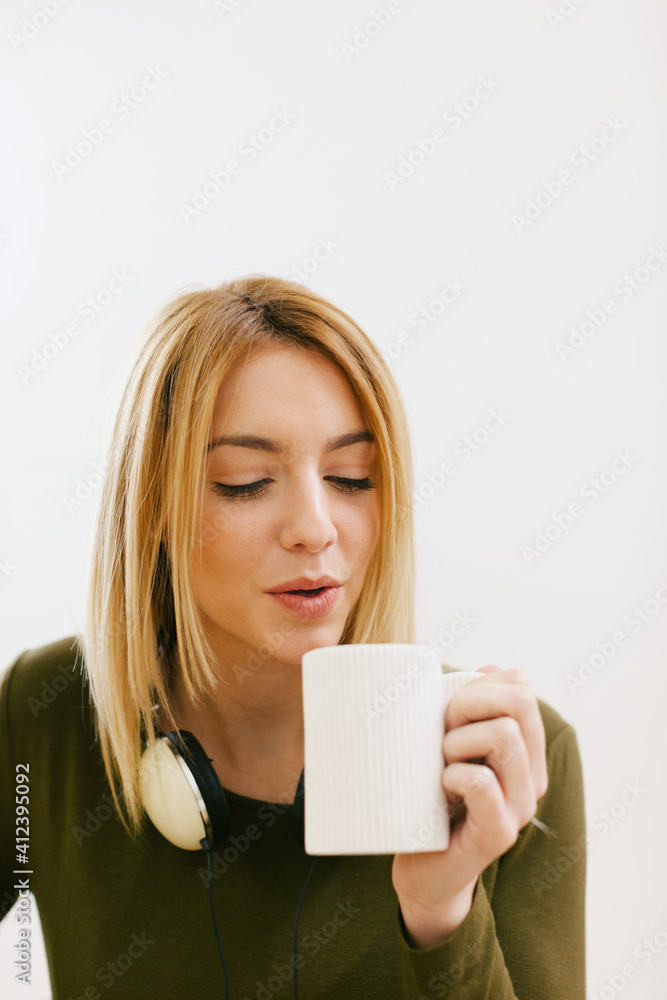 Young woman taking a break from painting in her new home. Young woman taking a break from painting in her new home.