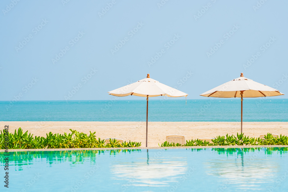 Umbrella and chair around outdoor swimming pool in hotel resort