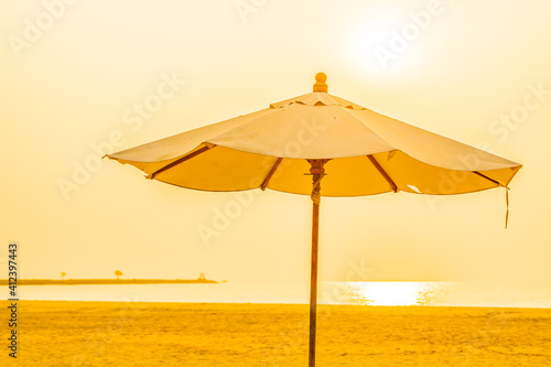 Umbrella and chair around outdoor beach sea ocean at sunset or sunrise