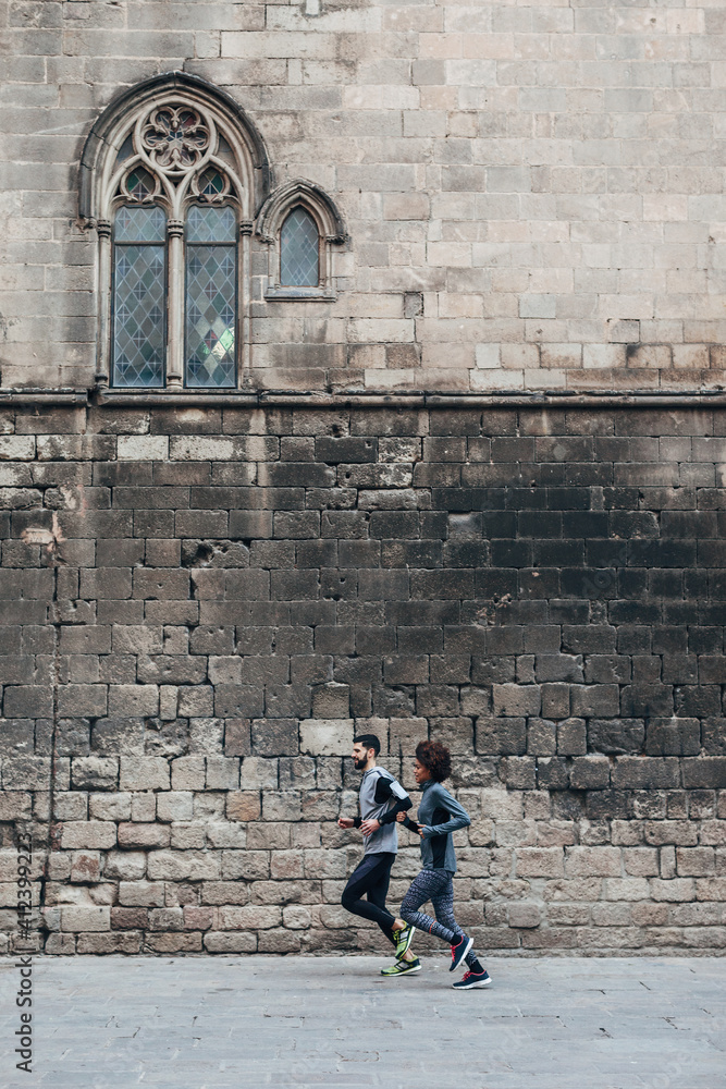 Young multiethnic couple running on the street. Young multiethnic couple running on the street.
