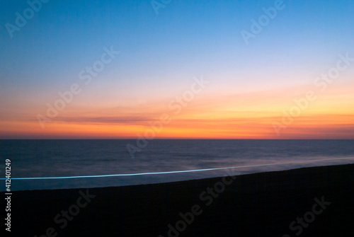 High tide and waves intensify in volcanic beach of Guatemala Monterrico at sunset, salt water, open air view.