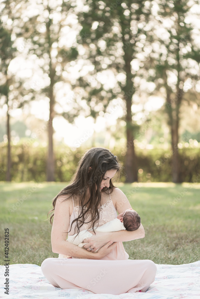 A Newborn Baby With Her Mother Outdoors On A Vintage Quilt A Newborn Baby With Her Mother Outdoors On A Vintage Quilt