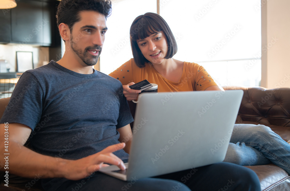 Young couple shopping online from home.