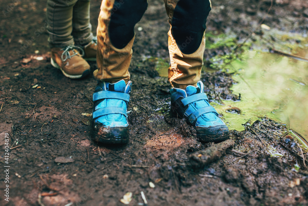 Closeup of a boy's boots next to the river. Closeup of a boy's boots next to the river.