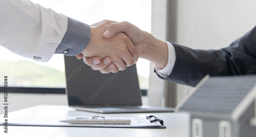 Real estate agents and customers shake hands to congratulate on signing a contract to buy a house with land and insurance, handshake and Good response concept. Real estate agents and customers shake hands to congratulate on signing a contract to buy a house with land and insurance, handshake and Good response concept.