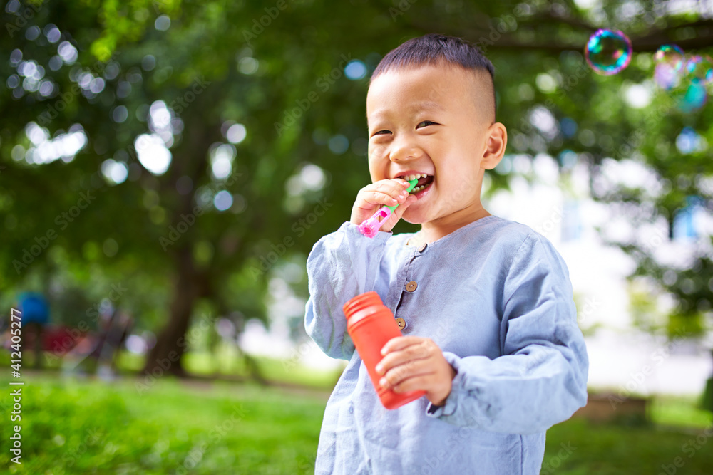 lovely little asian boy playing with bubble in the park lovely little asian boy playing with bubble in the park