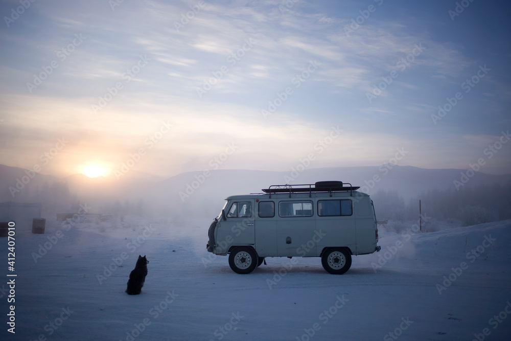 A dog waits next to a soviet-era van at a truck-stop in Siberia A dog waits next to a soviet-era van at a truck-stop in Siberia