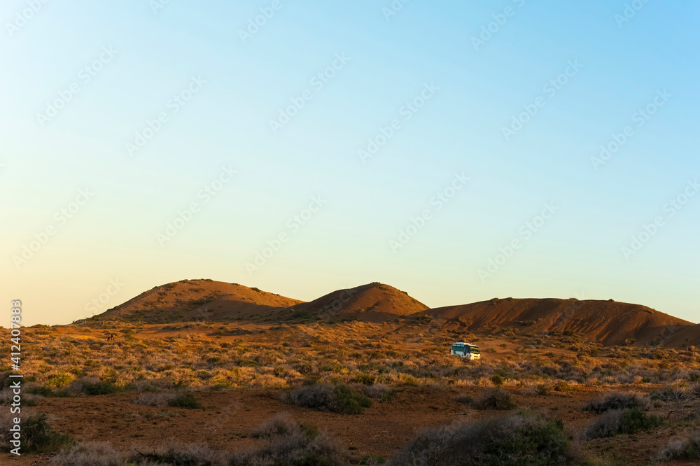Van crossing a desert landscape at sunset Van crossing a desert landscape at sunset