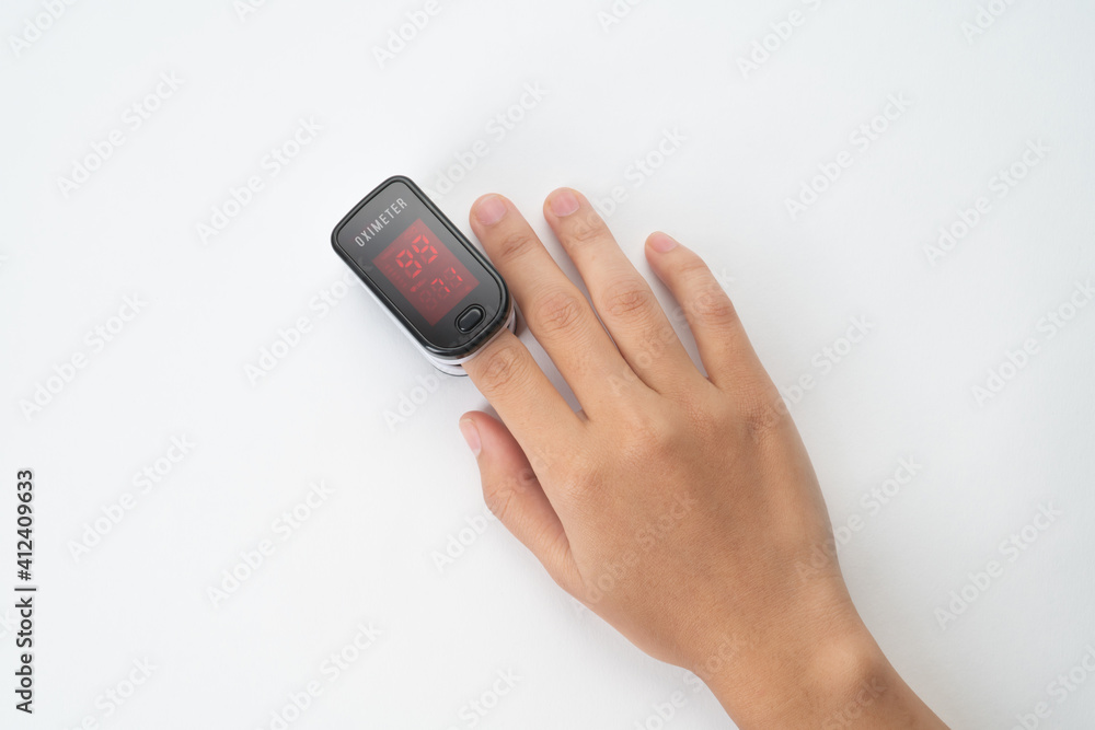 Top view of Pulse Oximeter, finger digital device to measure person's oxygen saturation. Reduced oxygenation is an emergency sign of pneumonia caused by flu or novel coronavirus. Device on Fingertip Top view of Pulse Oximeter, finger digital device to measure person's oxygen saturation. Reduced oxygenation is an emergency sign of pneumonia caused by flu or novel coronavirus. Device on Fingertip