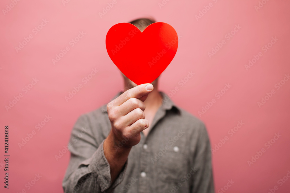 Man with a heart covering his face Man with a heart covering his face