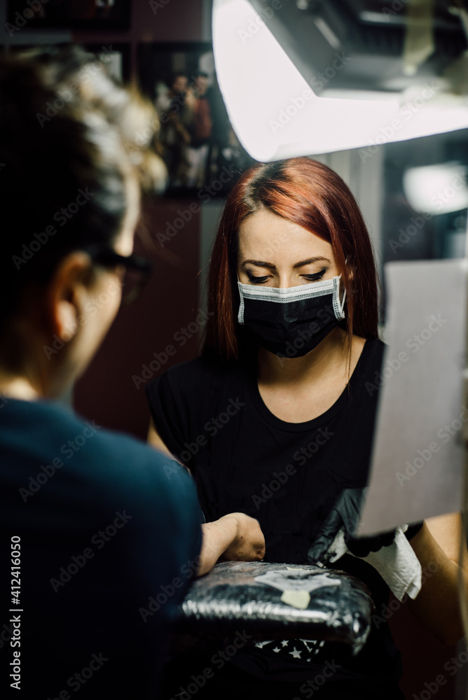 Tattoo artist drawing a tattoo Stock Photo Adobe Stock