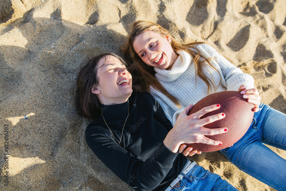 Happy best friends playing with a ball on the beach. Happy best friends playing with a ball on the beach.