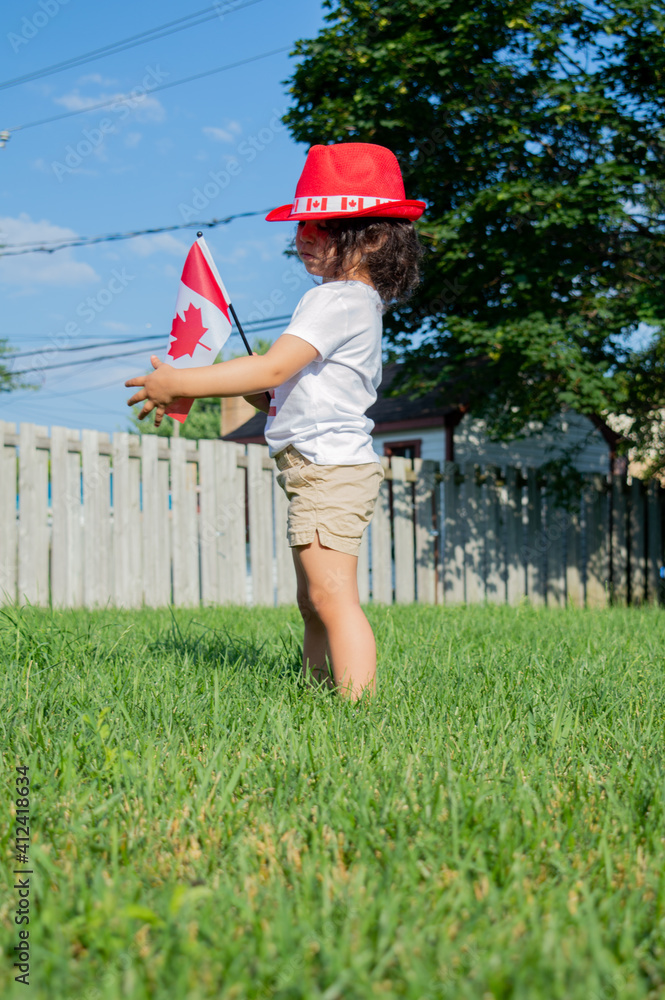 Kid citizen celebrating Canada Day holiday on first day of July. Canadian flag