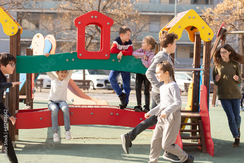 Smiling kids playing together on playground outdoors. High quality photo