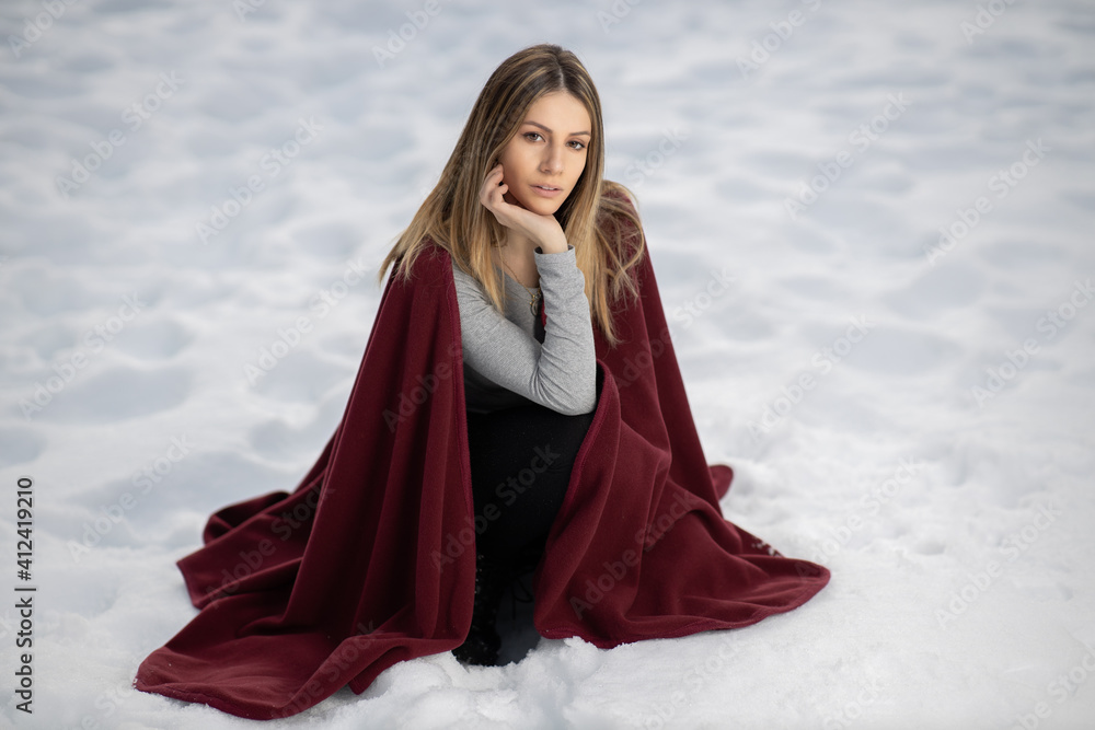portrait of blonde girl in a purple cloak on the snow in the mountains in winter panorama near a forest
portrait of blonde girl in a purple cloak on the snow in the mountains in winter panorama near a forest