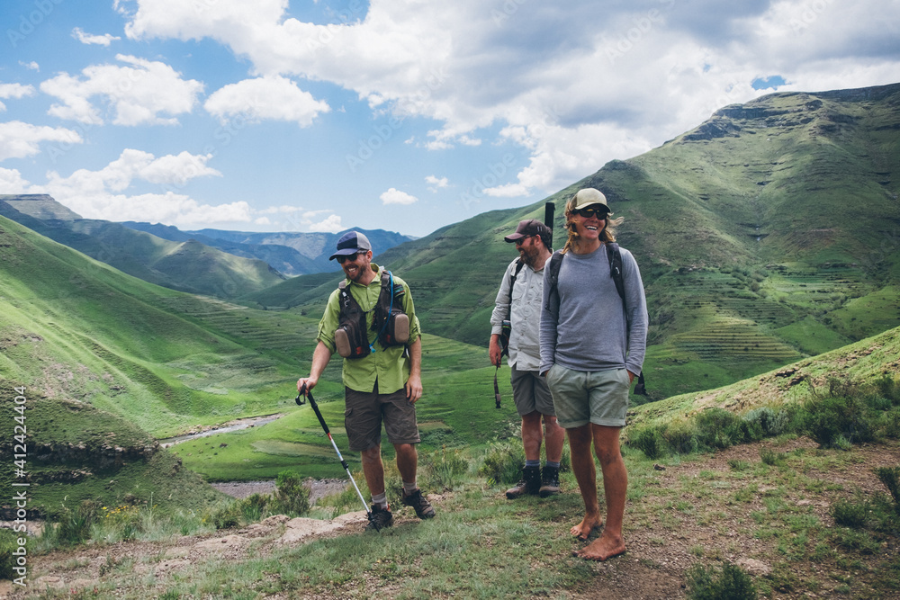Hikers taking a break in green mountainous valley Hikers taking a break in green mountainous valley
