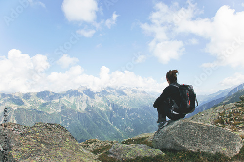 Mountaineering woman sitting on top of mountain contempling the landscape. photo