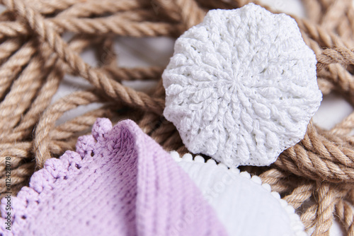 handmade embroidery on a wooden table. Next to the thread in the skeins for yarn. Cozy home arrangement made of ecological materials