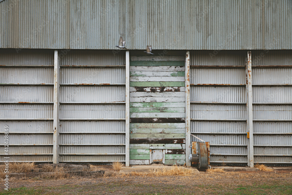 old rural building with worn and weathered wooden boards with peeling shades of green paint old rural building with worn and weathered wooden boards with peeling shades of green paint