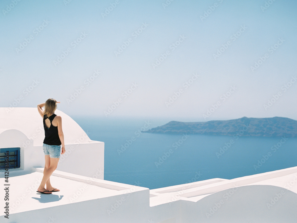 Woman enjoying landscape of Santorini, Greece Woman enjoying landscape of Santorini, Greece