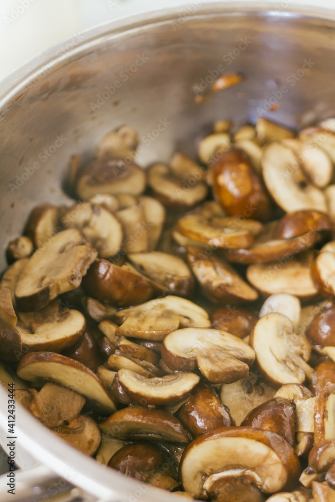 Sliced chestnut mushrooms frying in olive oil and garlic Sliced chestnut mushrooms frying in olive oil and garlic