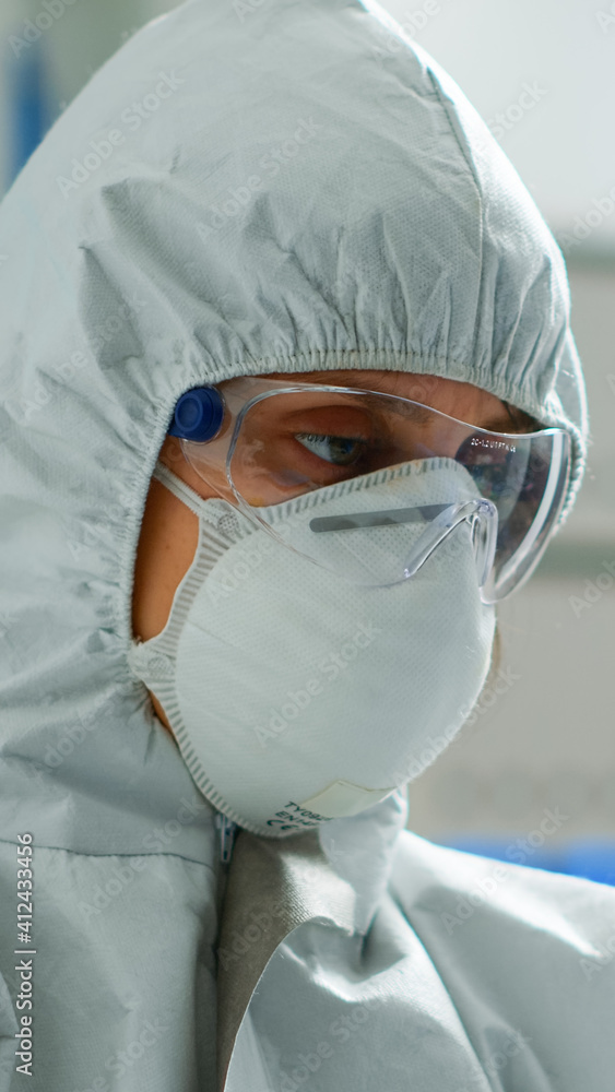 Scientist in coverall doing research analysing liquid in tube at modern equipped laboratory. Biochemist examining vaccine evolution using high tech for treatment development against covid19 virus Scientist in coverall doing research analysing liquid in tube at modern equipped laboratory. Biochemist examining vaccine evolution using high tech for treatment development against covid19 virus