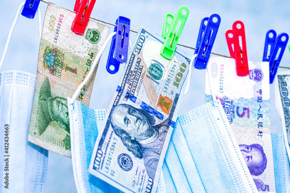 the concept of making money on a pandemic hygiene masks dollars and yuan hang on a clothesline close-up the concept of making money on a pandemic hygiene masks dollars and yuan hang on a clothesline close-up